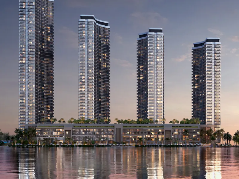 The towers lit at dusk above the podium and the water