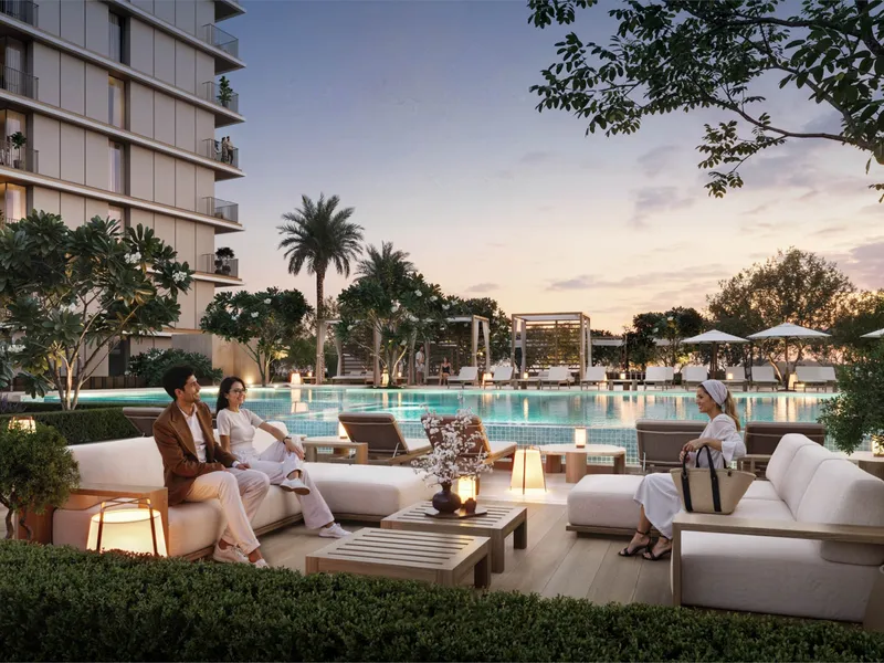 Evening view of the pool terrace with lounge seating and palms
